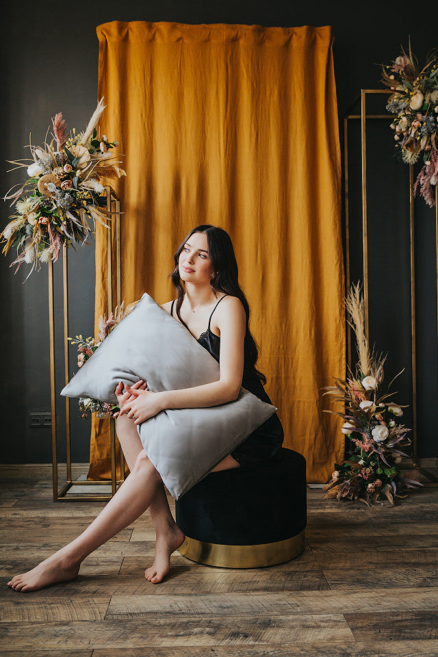 sieviete tur rokās spilvenu ar zīda spilvendranu