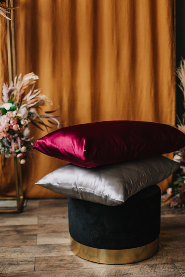 bordeoux and silver pillowcase on pillow on the chair from side