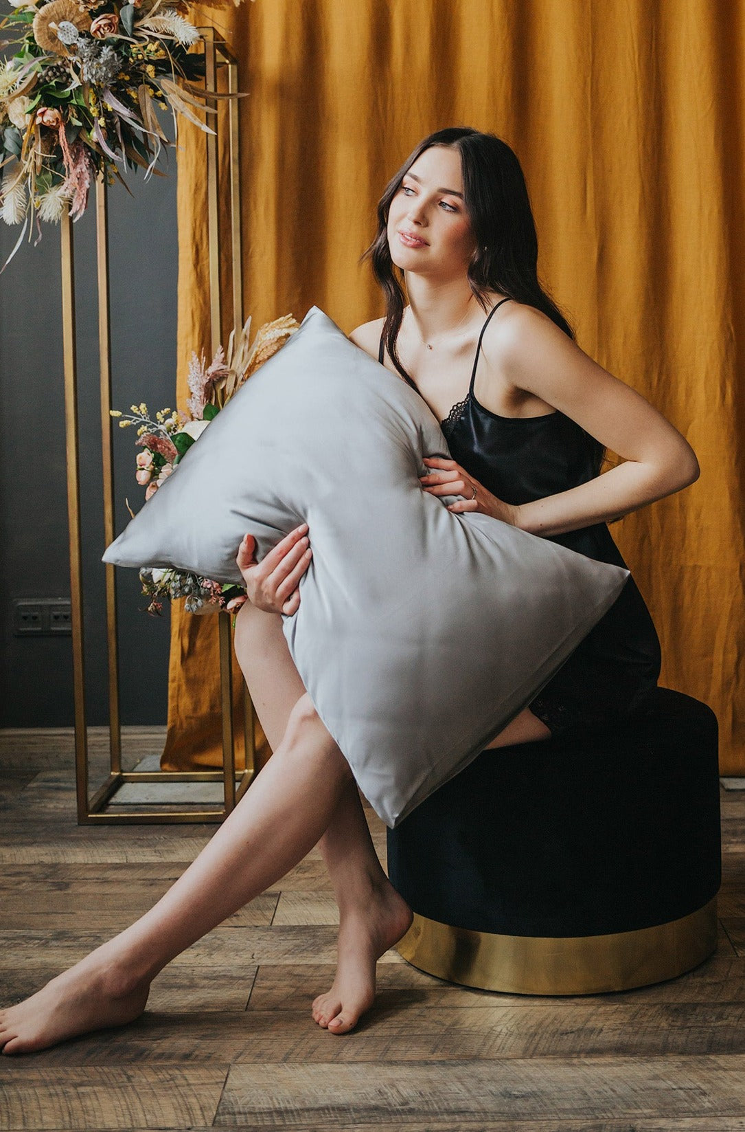 sieviete tur rokās spilvenu ar pelēku zīda spilvendranu, 50x70 cm