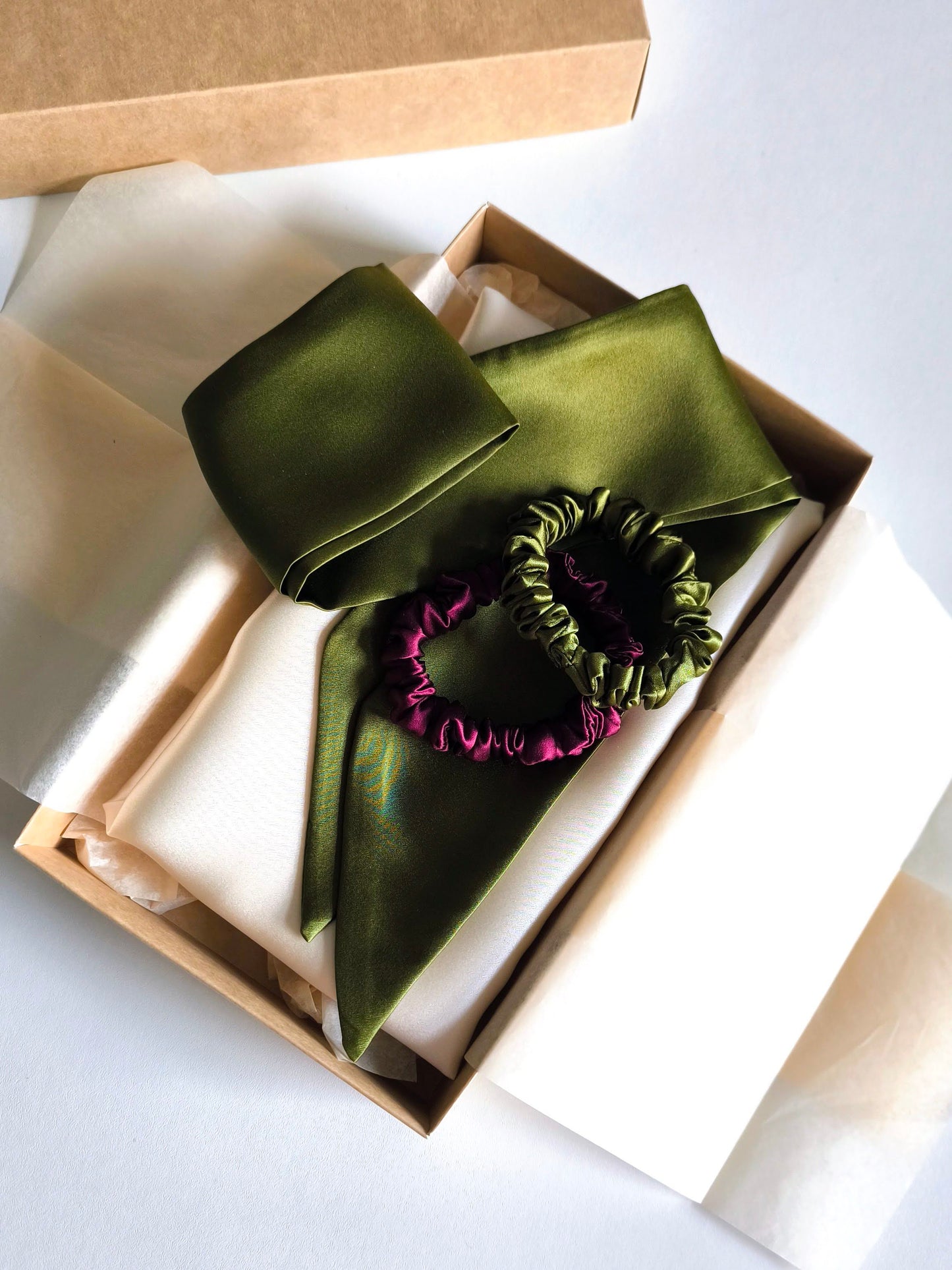 Set of green satin hair accessories including a scarf, headband, and scrunchie in a box.
