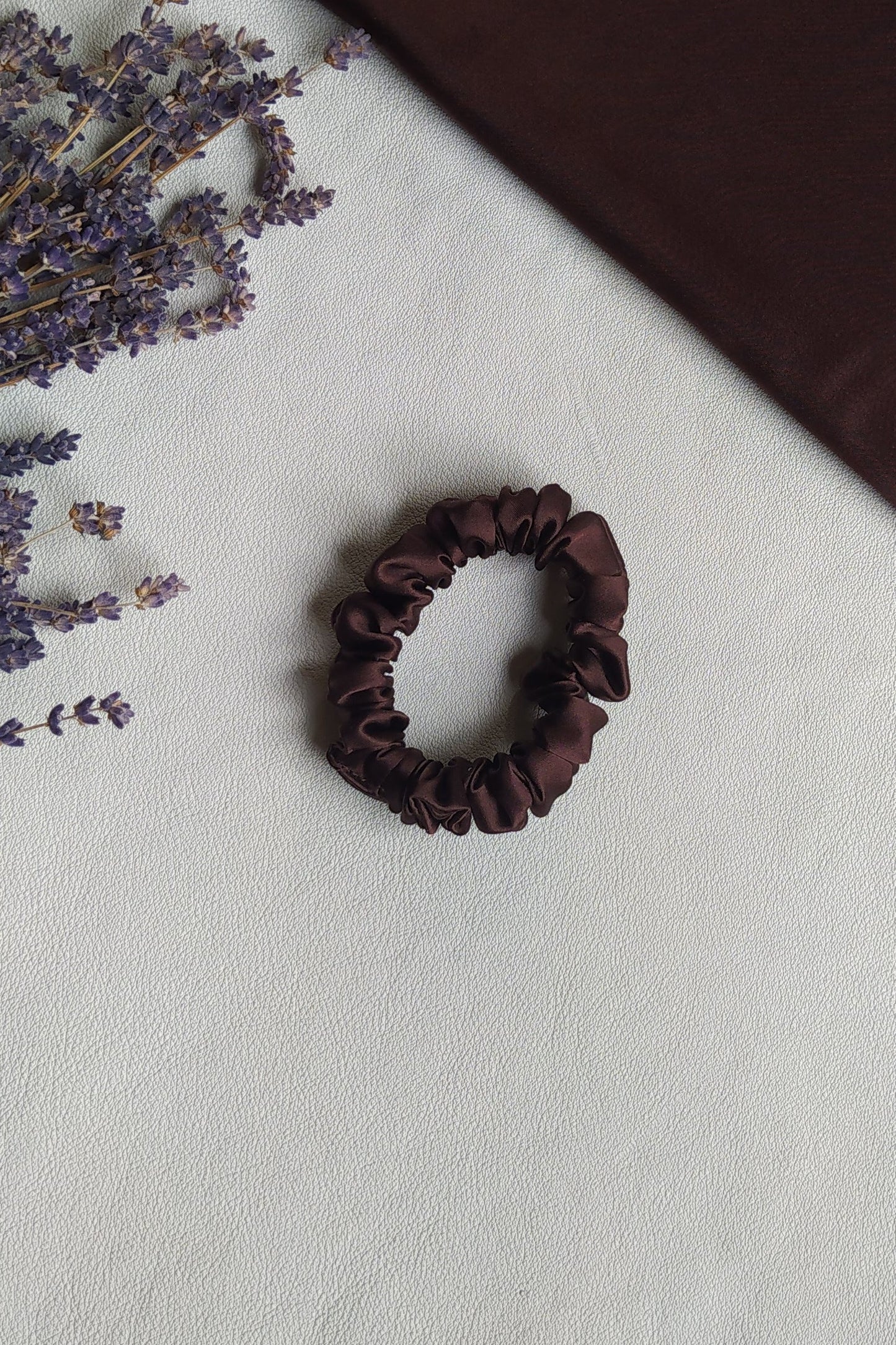 Brūna dabīgā zīda matu gumijas, S izmērs, uz galda