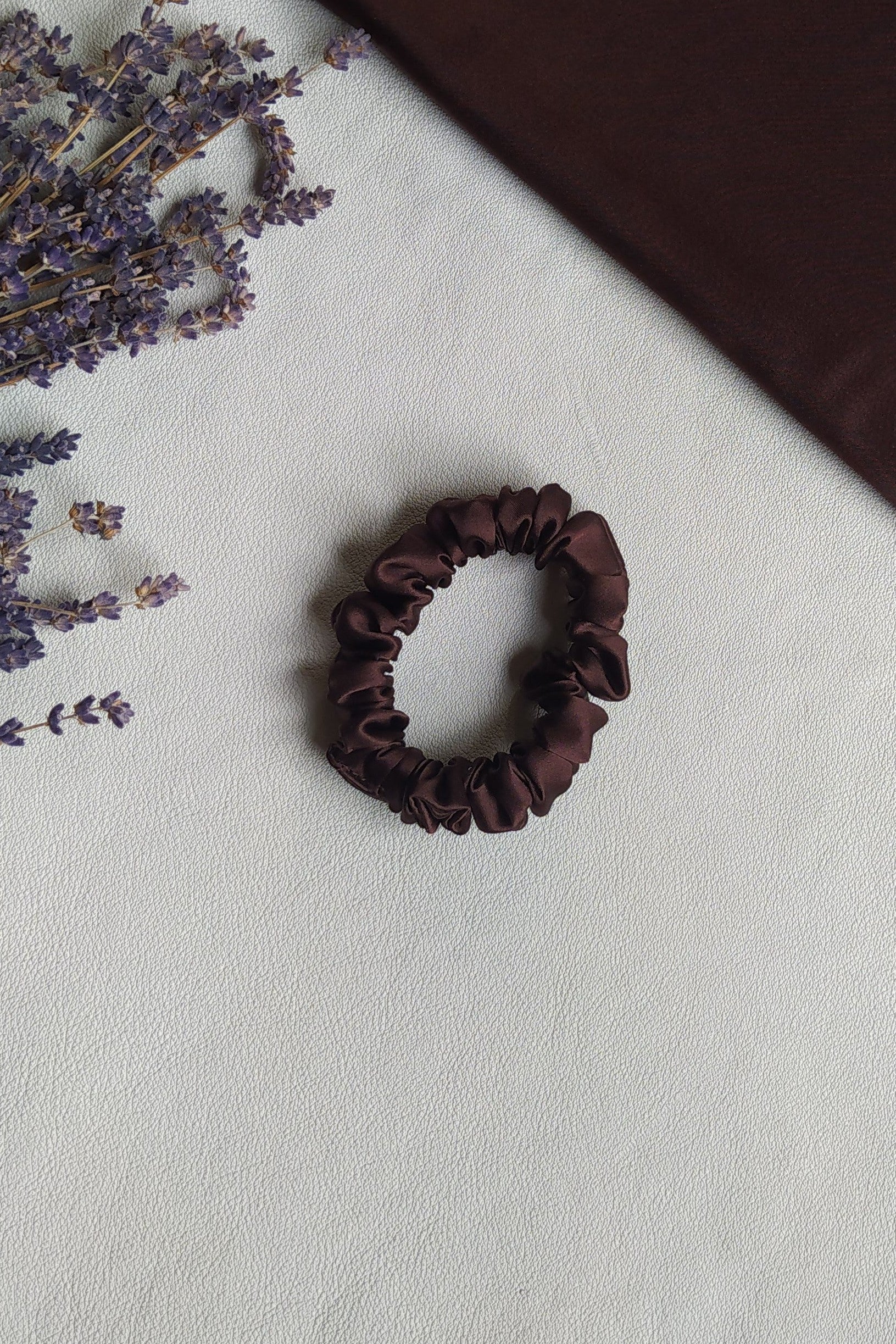 Brūna dabīgā zīda matu gumijas, S izmērs, uz galda