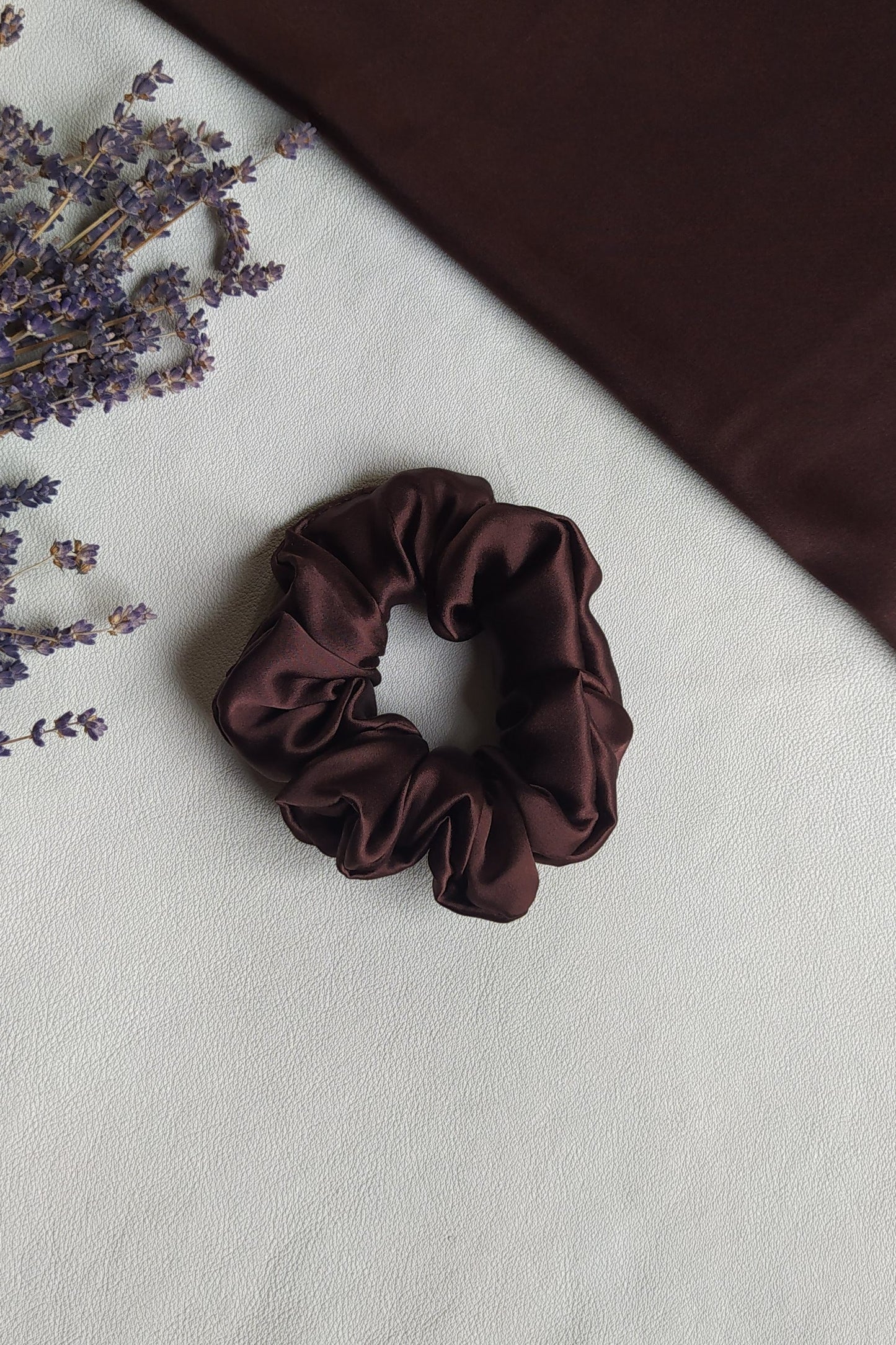 Brūna dabīgā zīda matu gumija, M izmērs, uz galda