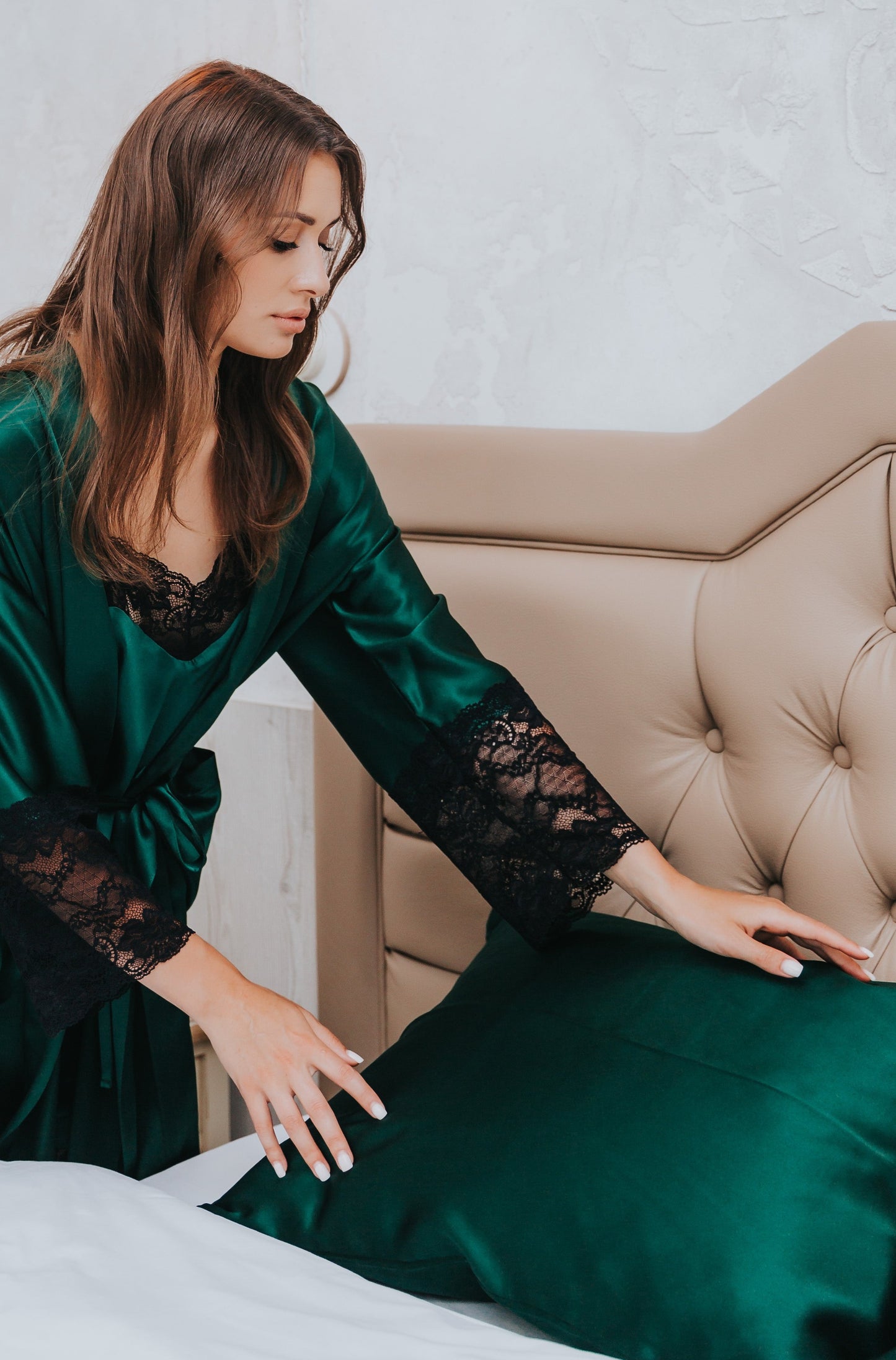 zaļa zīda spilvendrāna, sieviete liek uz gultas spilvenu, gulta