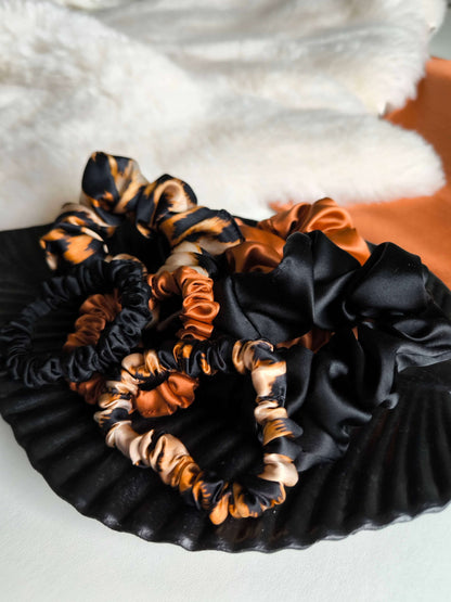 Black and orange scrunchies on a textured white surface