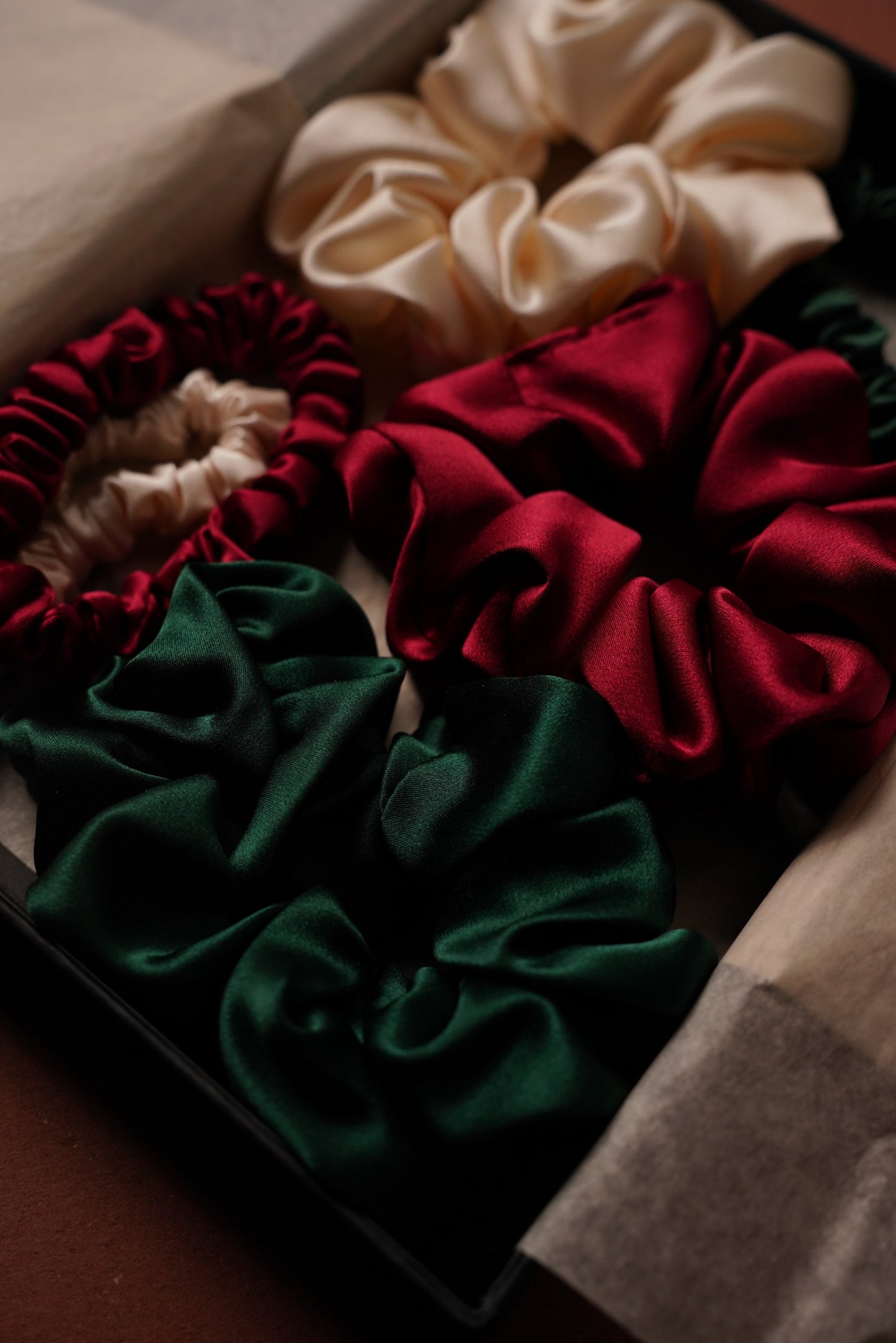 Set of red, green, and beige scrunchies in a box.