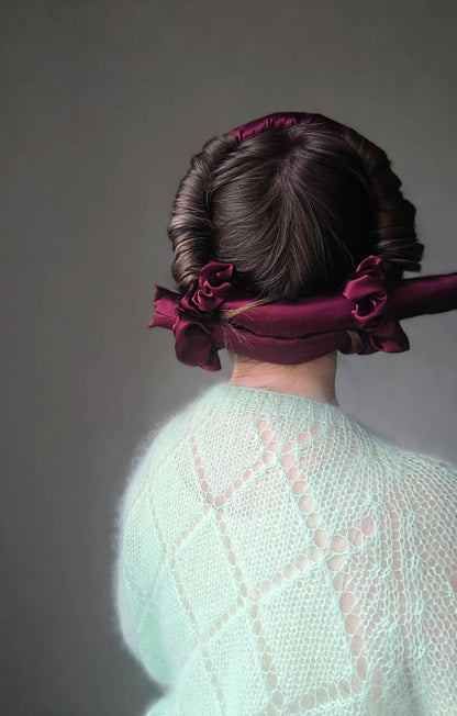Person wearing a silk hair curler on a plain background