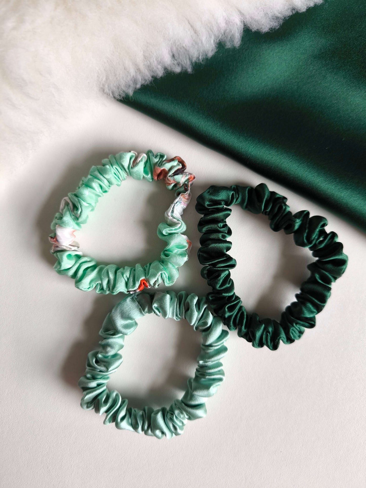 Three green scrunchies on a light background