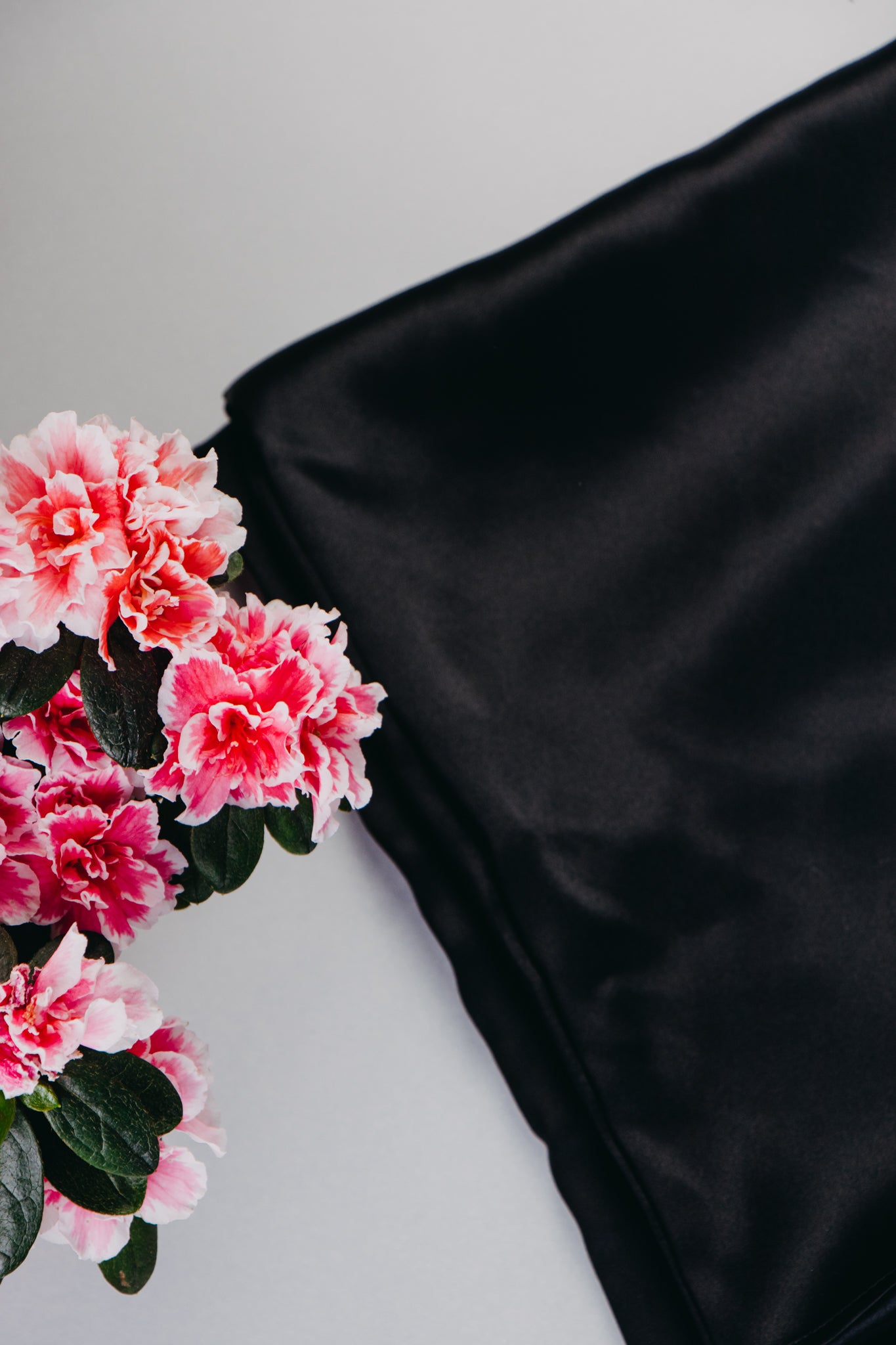 black pillowcase with pink flowers by side